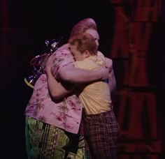 two people hugging each other on stage