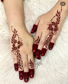 two hands with henna tattoos on them, one is red and the other is white