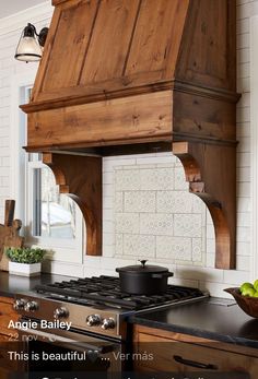 an image of a kitchen with wooden cabinets and stove top hood over the range that is made out of wood