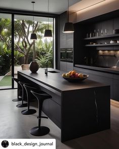 a bowl of fruit sitting on top of a counter in a kitchen next to a window