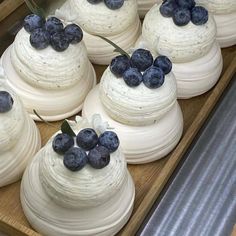 blueberries are on top of white cakes in a bakery