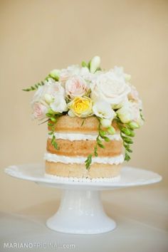 a cake with flowers and greenery on top