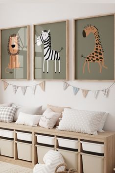 three children's art prints hanging on the wall above a bench with storage bins