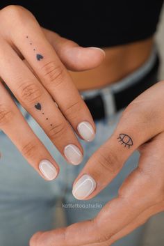 two hands with small tattoos on their fingers