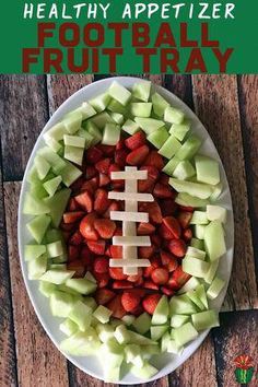 a football shaped fruit tray with apples, celery and strawberries