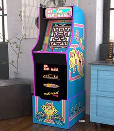 an arcade machine sitting on top of a hard wood floor next to a blue dresser