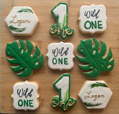 decorated cookies with green and white frosting are arranged on a cutting board, including one for the first year