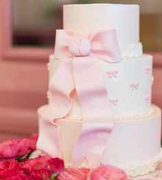 a three tiered wedding cake with pink flowers