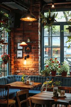 the interior of a restaurant with wooden tables and blue couches, potted plants on the windows