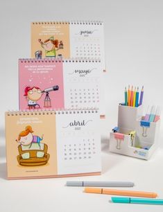 two calendars with pens and pencils next to each other