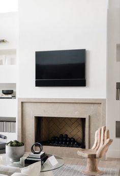 a living room with a fireplace and television mounted above it