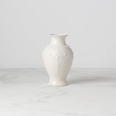 a white vase sitting on top of a marble counter