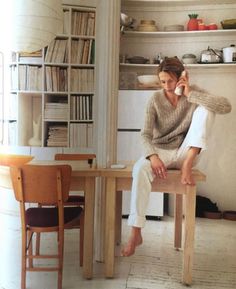 a woman sitting at a table talking on the phone