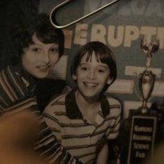 two young boys are posing with their trophies