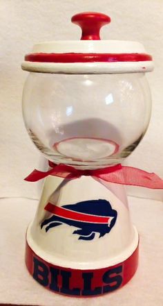 a glass bowl with buffalo bills logo on it and a red ribbon around the bottom