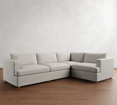 a white couch sitting on top of a hard wood floor next to a wooden floor