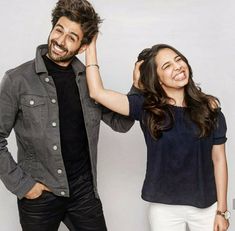 a man standing next to a woman who is holding her hair