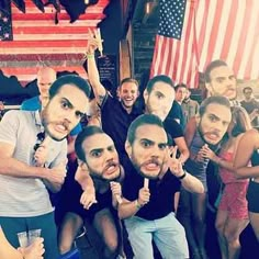 a group of people posing for a photo in front of an american flag wallpaper