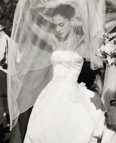 black and white photograph of a woman in a wedding dress with veil over her head