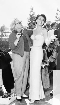 an old black and white photo of two women in front of a group of people