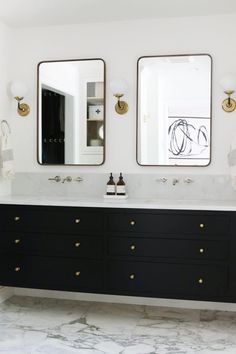 a bathroom with double sinks and two mirrors on the wall above them, along with marble flooring