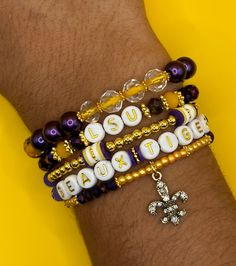 Elevate your LSU Tigers spirit with this set of five vibrant and stylish bracelets. Whether you're a passionate fan, an alum, or simply love showing off your Louisiana State University pride, these bracelets are the perfect accessory for any occasion. Product Details: *Handcrafted with care, these bracelets feature high-quality beads in the iconic purple and gold colors of the LSU Tigers. *Each set contains five unique bracelets, giving you the freedom to mix and match or share with fellow fans. Stacked Round Beads Jewelry For Gift, Stacked Round Beads Jewelry Gift, Stacked Round Beads Jewelry As Gift, Stacked Round Beads Bracelets As Gift, Customizable Adjustable Yellow Jewelry, Adjustable Customizable Yellow Jewelry, Lsu Party, Tech Bracelet, Stack Of Bracelets