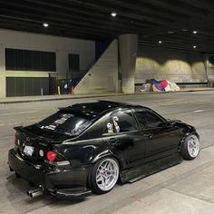 a black car parked in front of a parking garage