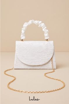 There is no easier way to elevate your springtime looks than with the Lulus Exceptional Class Ivory Lace Ruched Handle Mini Handbag! Chic floral lace (atop woven satin) shapes this cute mini bag that boasts a structured silhouette, a ruched satin top handle with gold beaded accents, and a flat bottom design. The front flap features a hidden magnetic closure that opens to reveal a lined, compact interior with a sidewall pocket. Attach the removable gold chain strap when you want a crossbody look! Spring Evening Bag With Pearl Handle, Spring Party Bags With Pearl Handle, Elegant Wedding Bag For Summer, Elegant Summer Wedding Bag, Elegant Summer Wedding Bags, Cream Bags With Pearl Handle For Spring, Spring Cream Bags With Pearl Handle, Elegant Evening Bag For Spring Events, White Elegant Evening Bag For Summer