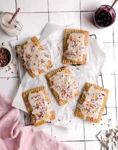 some cookies with icing and sprinkles on a table