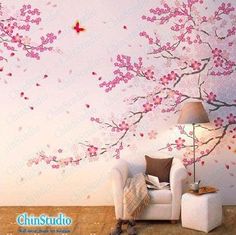 a red couch sitting in front of a wall with pink flowers and butterflies on it