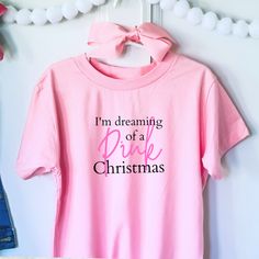 If you love pink and Christmas, then chances are you may be dreaming of a pink Christmas! Enjoy this fun and creative pink shirt to celebrate this holiday season. Description: This tee is light, comfy, and has just the right amount of stretch youngsters need for an active lifestyle. 100% combed and ring-spun cotton*. Relaxed unisex fit. Pre-shrunk. Reads: I'm dreaming of a pink Christmas FEATURED COLOR IN PHOTO: Blushing Pink AVAILABLE COLORS: Blushing pink, white. AVAILABLE SIZES: 2T, 4T, 6T, Y Thanksgiving Pregnancy Shirt, Pink Christmas Shirt, Dreaming Of A Pink Christmas, A Pink Christmas, Christmas Shirts For Kids, Christmas Kids, Family Tees, Xmas Shirts, Mom Life Shirt