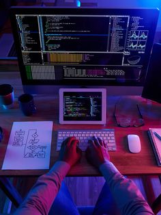 a person sitting in front of a computer on top of a desk with a keyboard and mouse