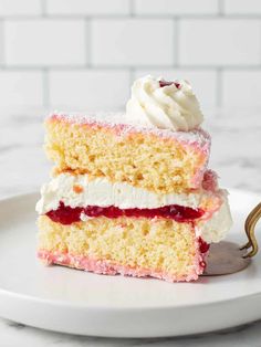 a piece of cake with white frosting and raspberry filling on a plate