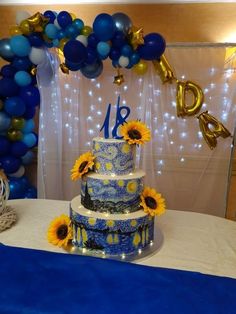 a blue and white wedding cake with sunflowers on the table in front of balloons