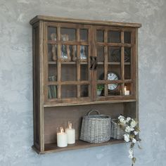 a wooden cabinet with glass doors and candles