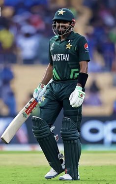 pakistan's cricket player walks off the field with his bat in hand during their match against india