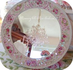 a pink and white plate with a chandelier hanging from it's side