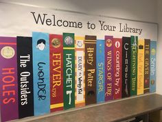 there are many books lined up on the wall in front of the library sign that says welcome to your library