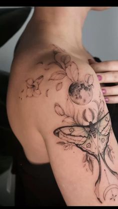 a woman's shoulder with flowers and a butterfly tattoo on her left side arm