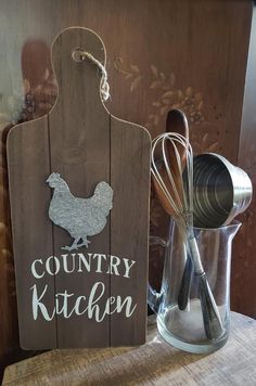 a wooden sign that says country kitchen with whisk and spoons in it