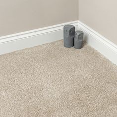 two gray vases sitting on the floor next to each other in a room with carpet