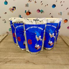 three sonic birthday cups sitting on top of a wooden table