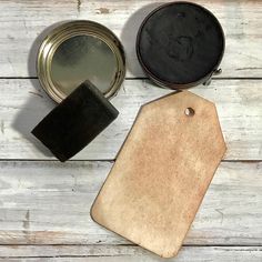 a wooden table with two tins and a tag on top of it next to some other items