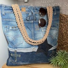 a pair of sunglasses sitting on top of a blue jean purse