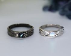 two wedding rings sitting next to each other on a table