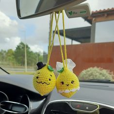 two crocheted lemons hanging from a car dashboard