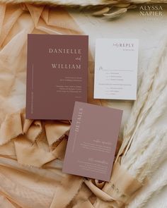 the wedding stationery is laid out on some fabric