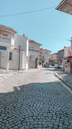 an empty cobblestone street with buildings in the background