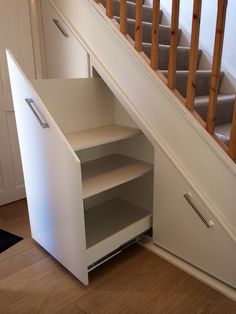 an open cabinet under the stairs in a house