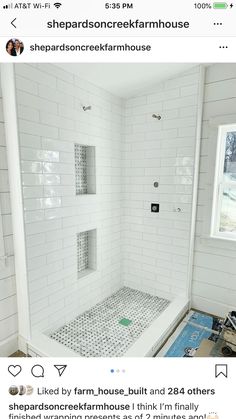 a white tiled shower with black and white tile on the floor, walls and ceiling